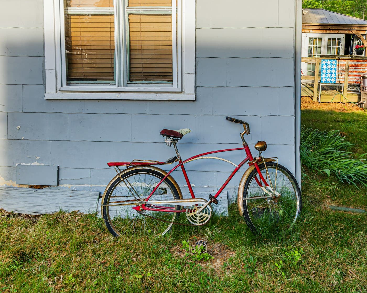 Red vintage bicycle leaning against a blue wall