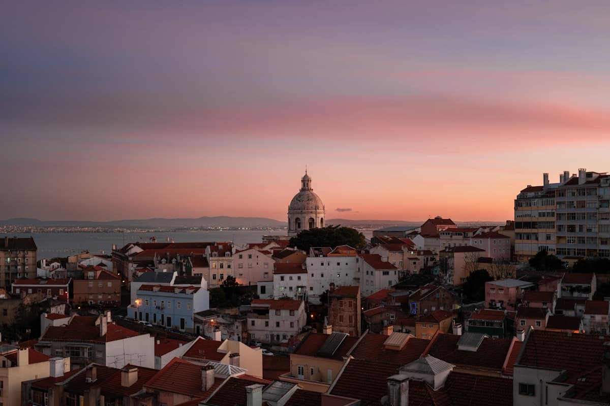 Vintage color photograph of a young traveler standing on a hilltop viewpoint looking over Lisbon