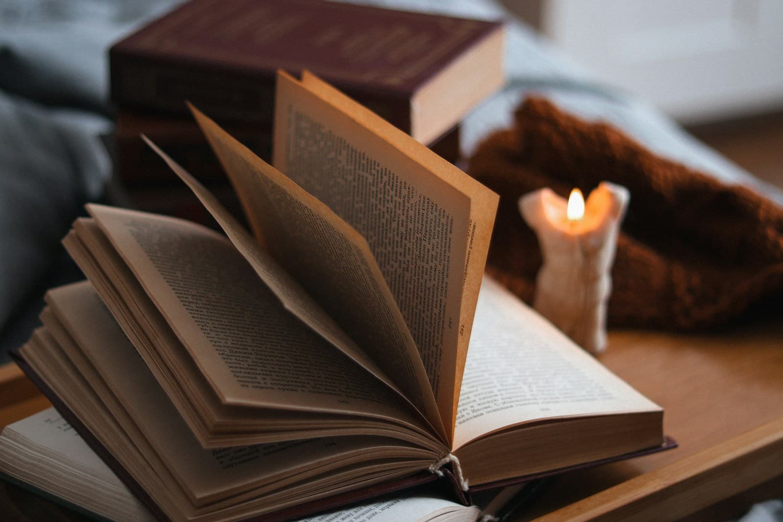 Open book with candlelight, warm amber tones